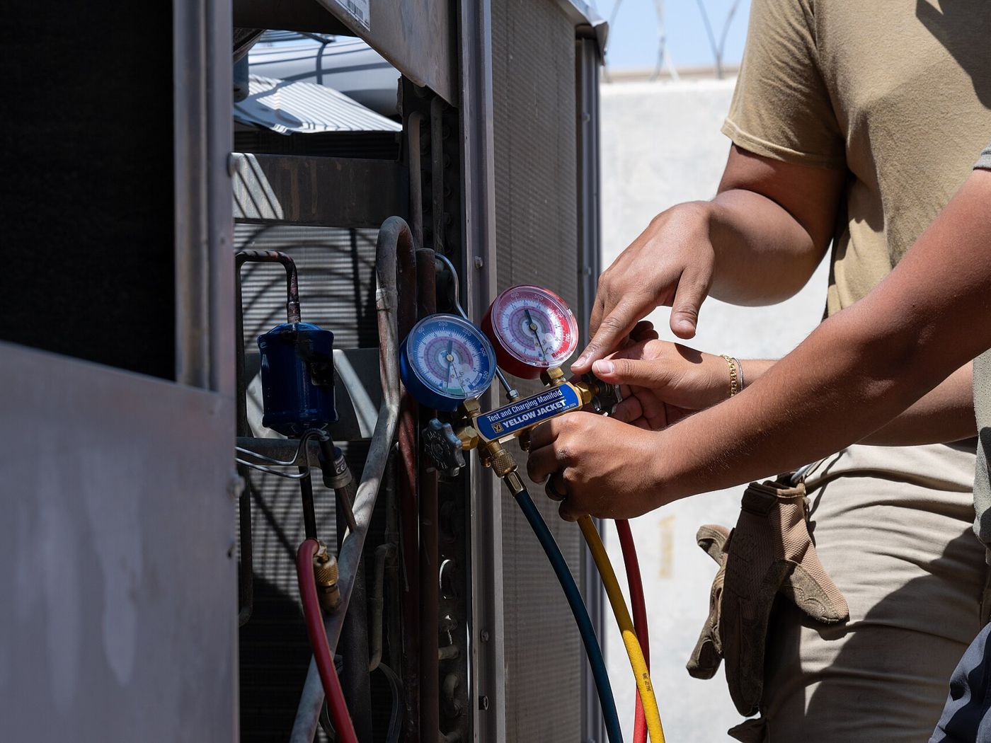 Kỹ thuật viên đo áp suất gas cục nóng điều hoà bằng đồng hồ chuyên dụng